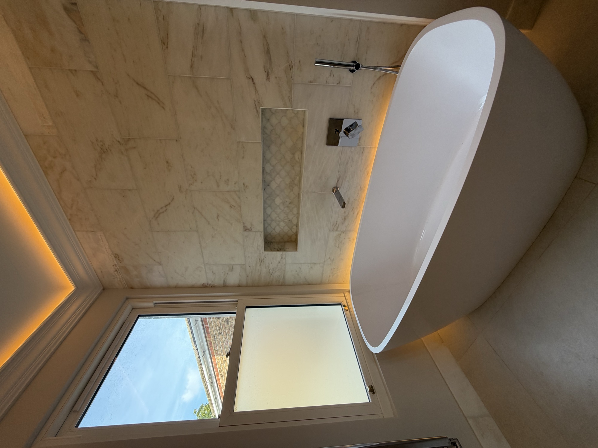 Portsmouth terrace house — freestanding bath against marble tiling