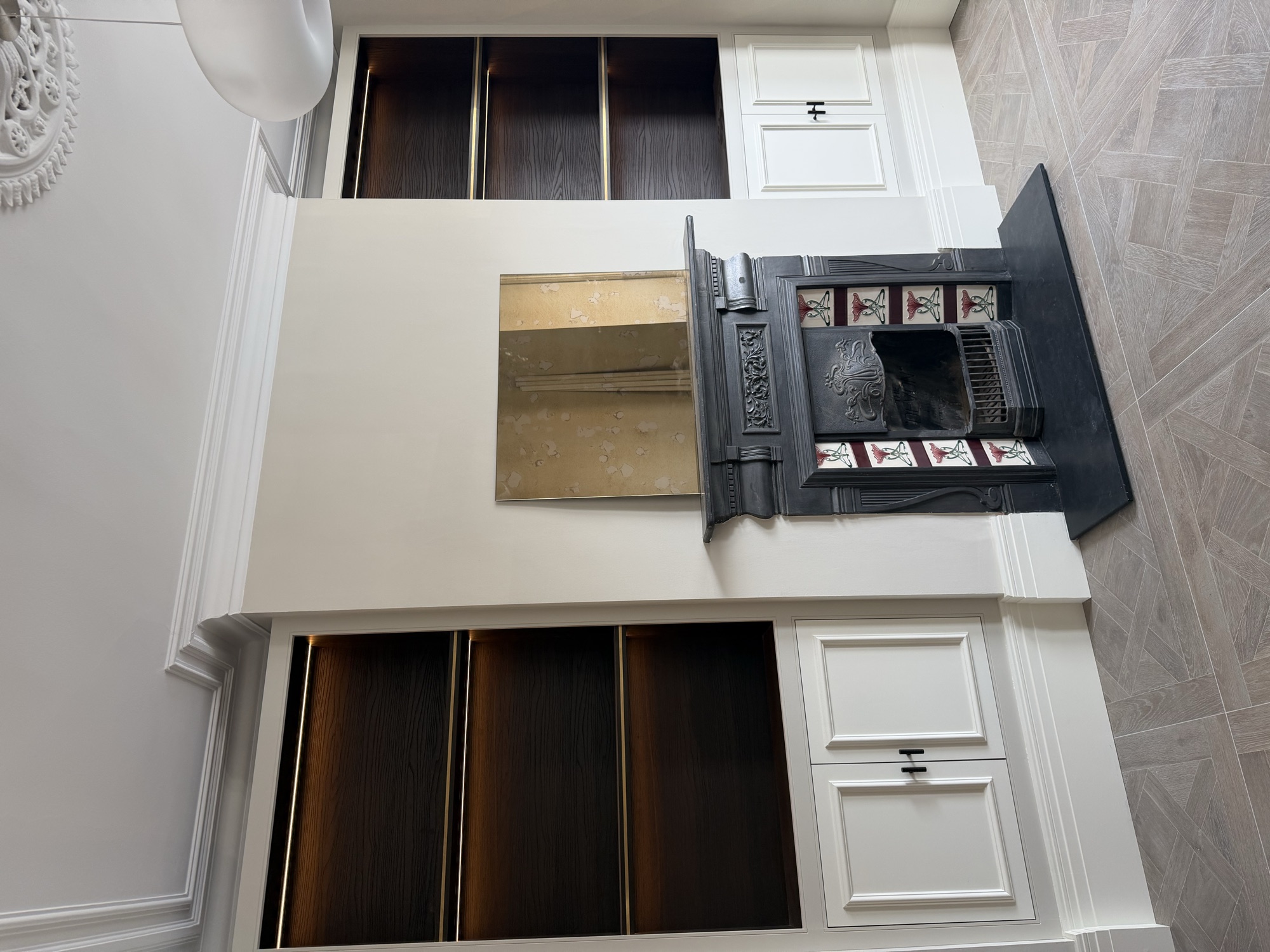 Portsmouth terrace house — restored fireplace between bespoke lit alcove joinery